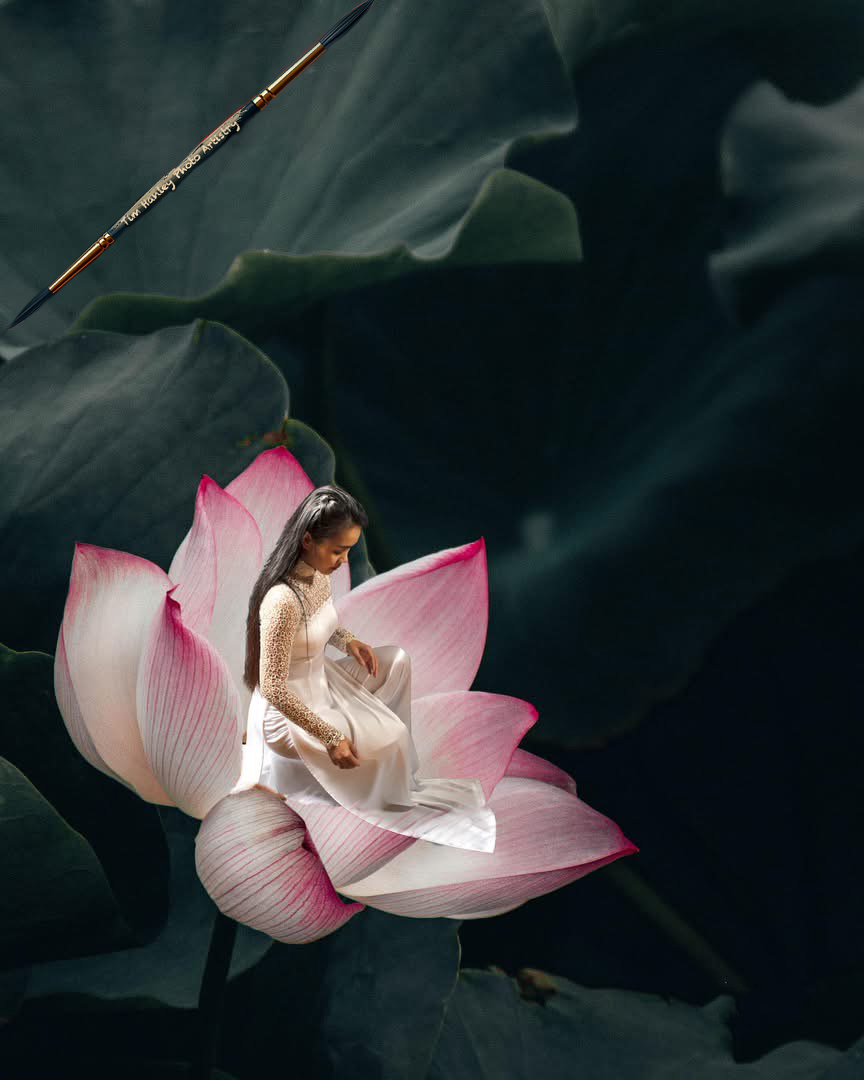 Woman in lace áo dài seated inside large lotus flower