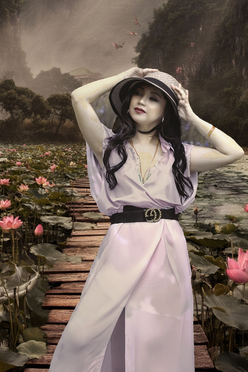 Woman on wooden boardwalk surrounded by lotus flowers