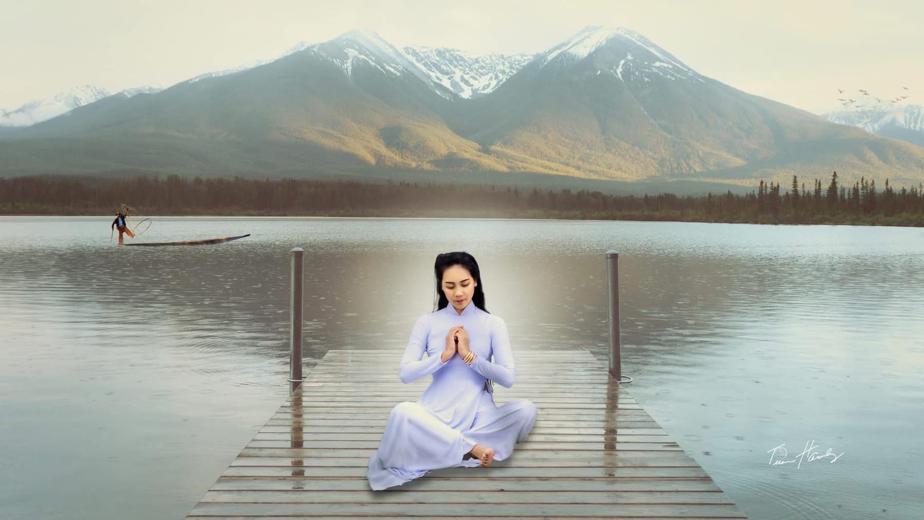 Woman in áo dài seated cross-legged on wooden dock