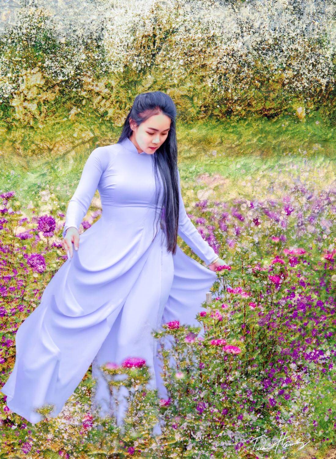 Woman in áo dài in painterly wildflower garden